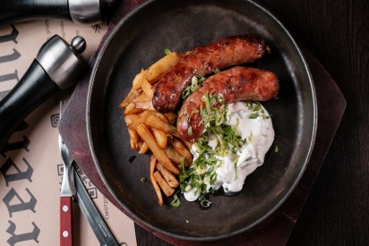Pork and beef sausage with fried potatoes and chanterelles in cold cream